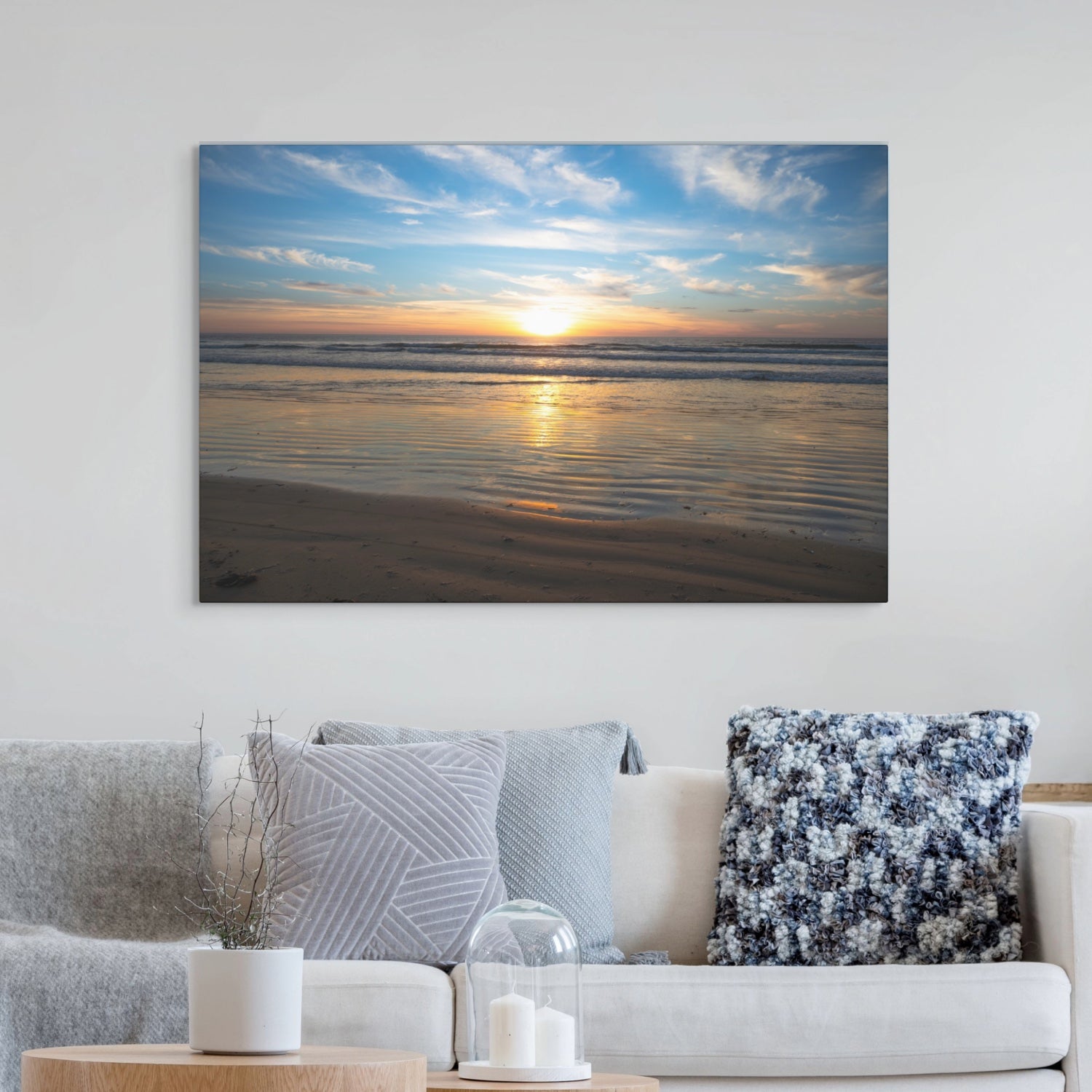 California beach sunset over the ocean with golden sand ripples canvas printabove a sofa with decorative pillows