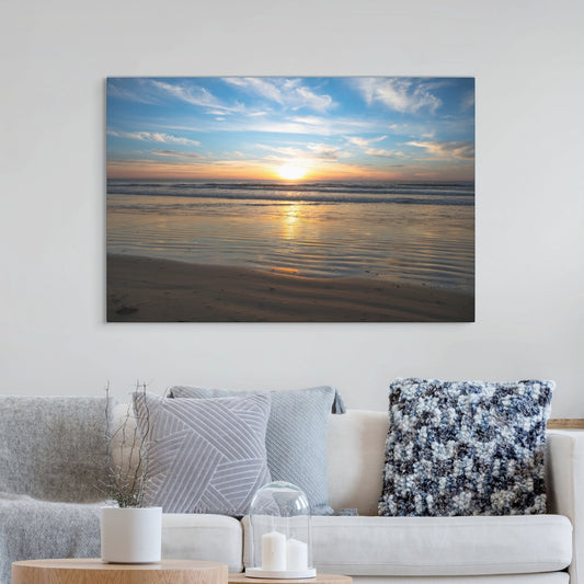 California beach sunset over the ocean with golden sand ripples canvas printabove a sofa with decorative pillows
