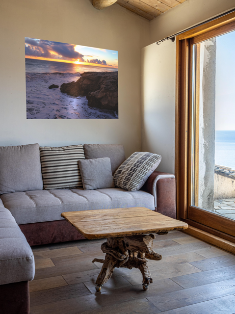 Living room with a gray sofa, wooden coffee table, and a California coastal sunset after rain storm canvas print.