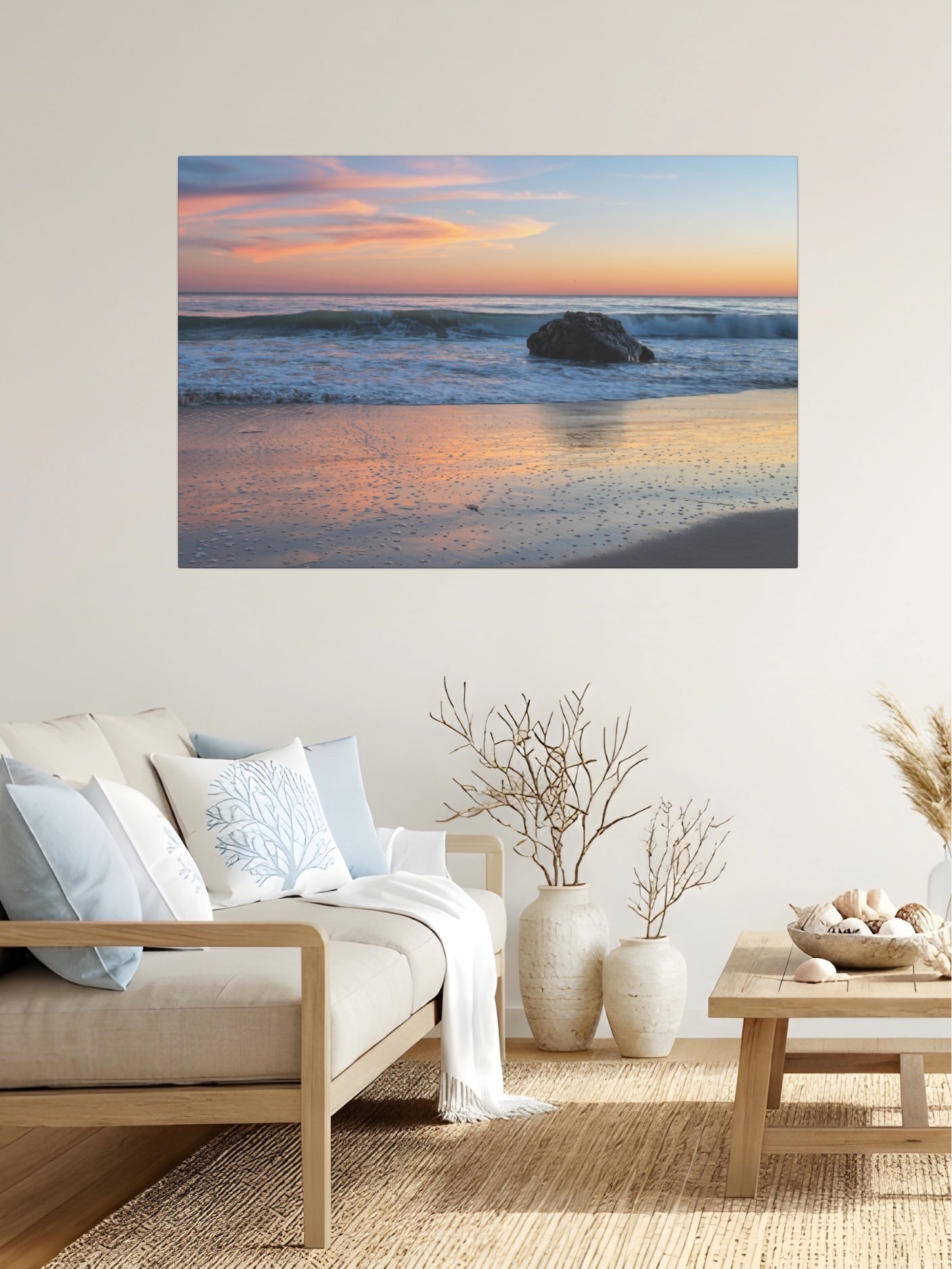 Pastel beach twilight canvas print with pink clouds reflecting on wet sand on a wall above a sofa in a living room