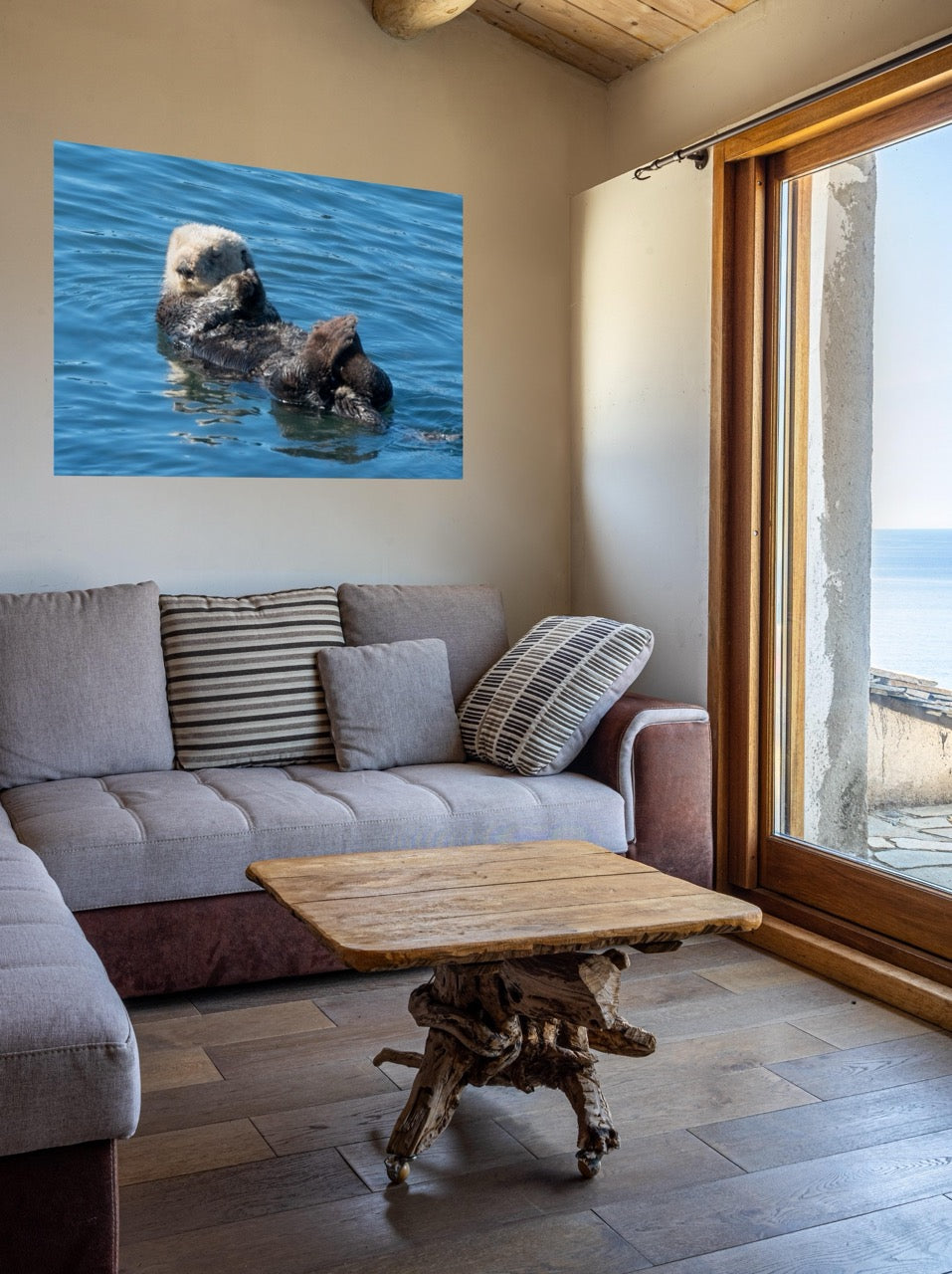 Living room with a sofa, coffee table, and wall art of an otter in water.