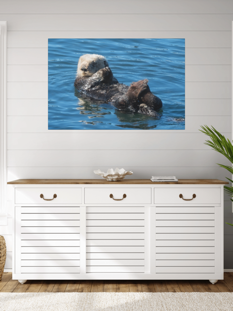 White cabinet with wooden top in a room with a sea otter canvas print on the wall.