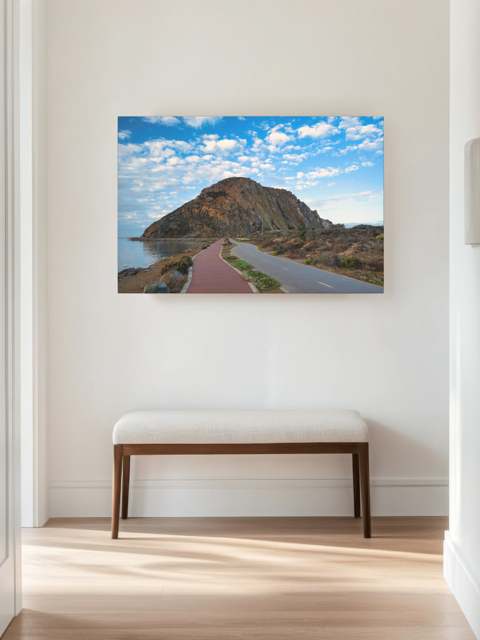 Road to Morro Rock canvas print with a bench below in a room.