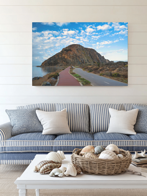 Living room with a couch, coffee table, and a Road to Morro Rock canvas print.