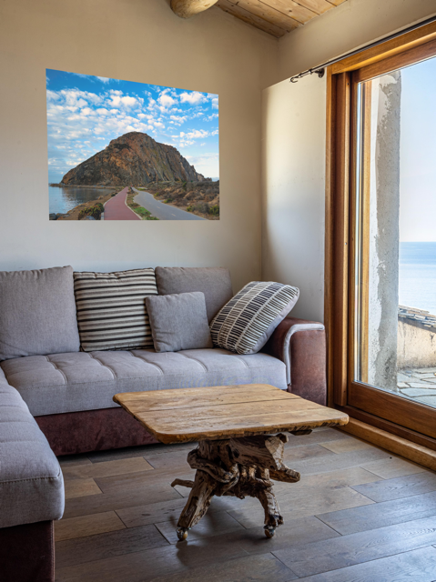 Living room with a gray sofa, wooden coffee table, and a Road to Morro Rock canvas print.