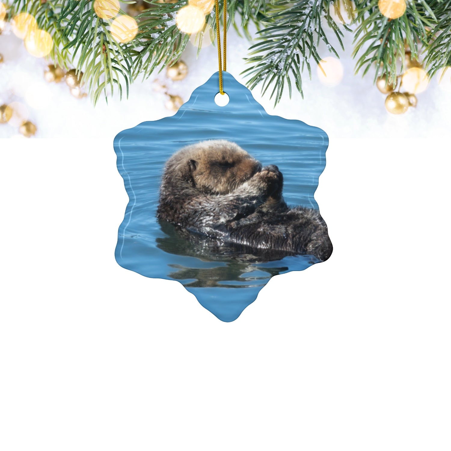 Ceramic Christmas ornament featuring a peaceful photograph of a sea otter with its eyes closed
