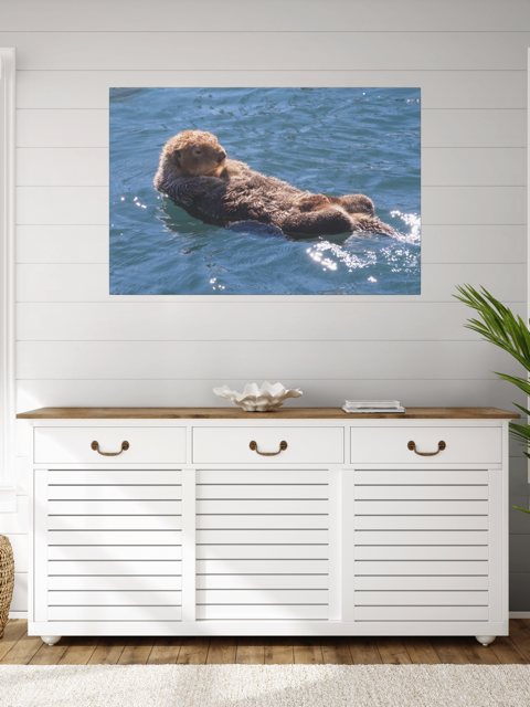 White storage cabinet with wooden top against a wall with an otter canvas print.