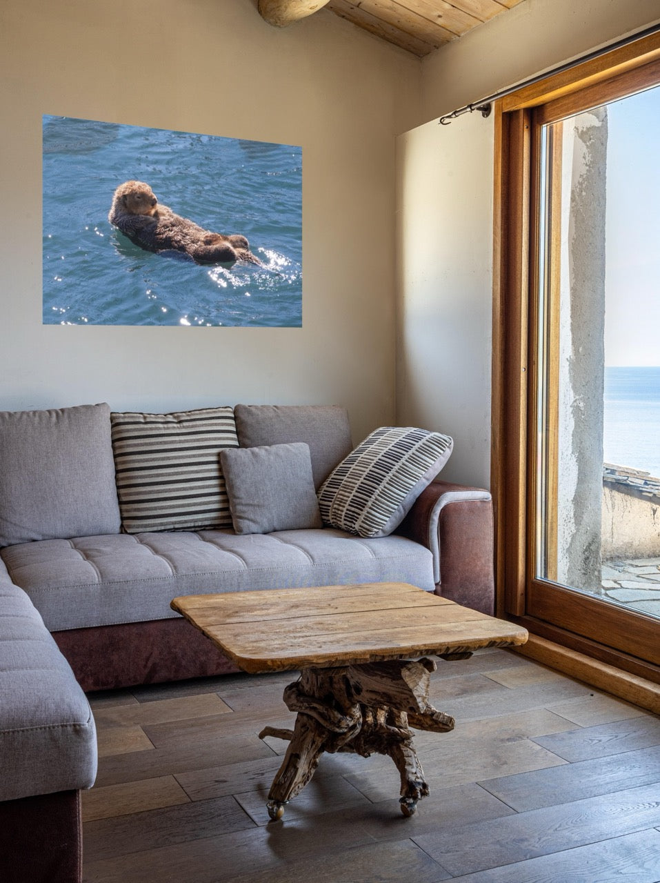 Living room with a gray sofa, wooden coffee table, and wall art of an otter.