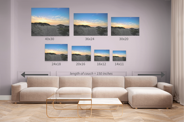 Canvas prints of a beach sunset over the sand dunes with dimensions displayed above a sofa.