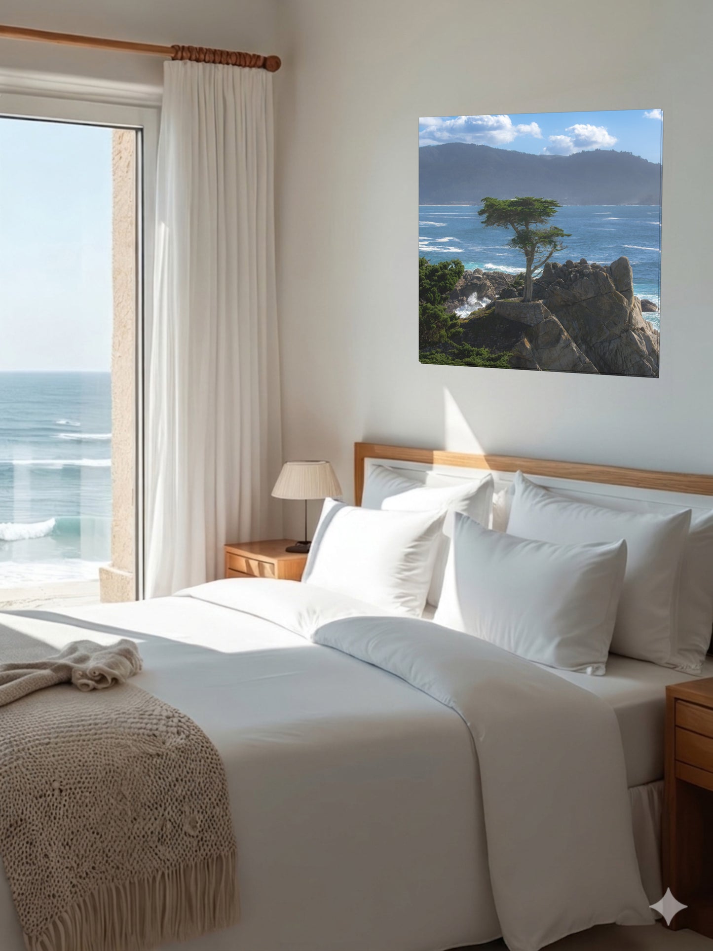 Bedroom with ocean view and a canvas print of the lone cypress tree at Pebble Beach on a rocky cliff on the wall.