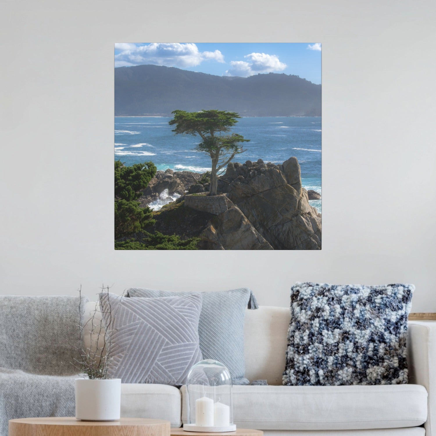Canvas print of the lone cypress tree at Pebble Beach on a rocky cliff, displayed above a living room sofa.