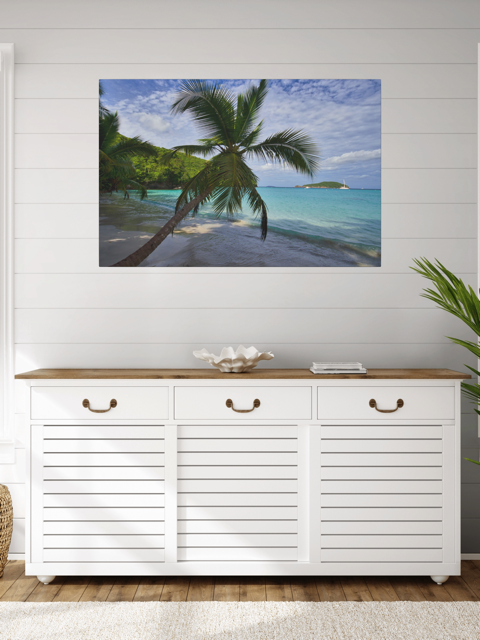 White cabinet with wooden top against a wall with a canvas print of a tropical beach scene.