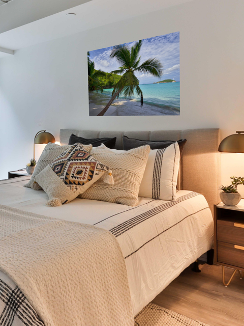 Bedroom with a canvas print of a tropical beach scene on the wall
