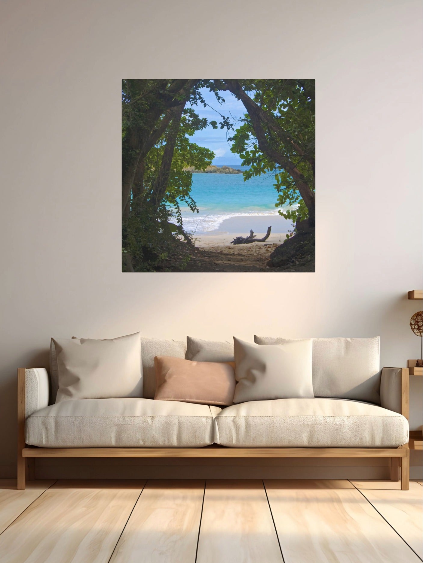 Tropical beach view through trees Hawaiian island canvas print on a wall above a sofa.