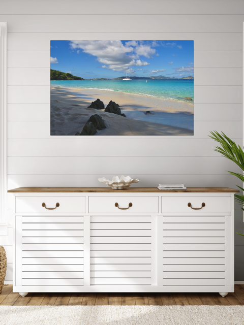 White cabinet with wooden top below a a canvas print of a tropical beach scene on a white wall.
