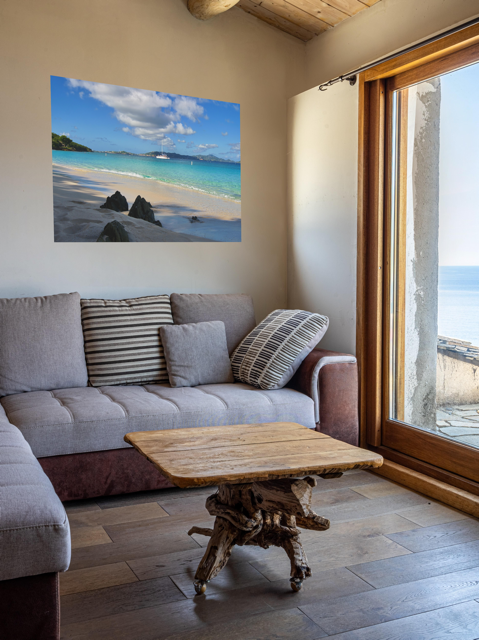 Living room with a gray sofa, wooden coffee table, and a canvas print of a tropical beach scene.