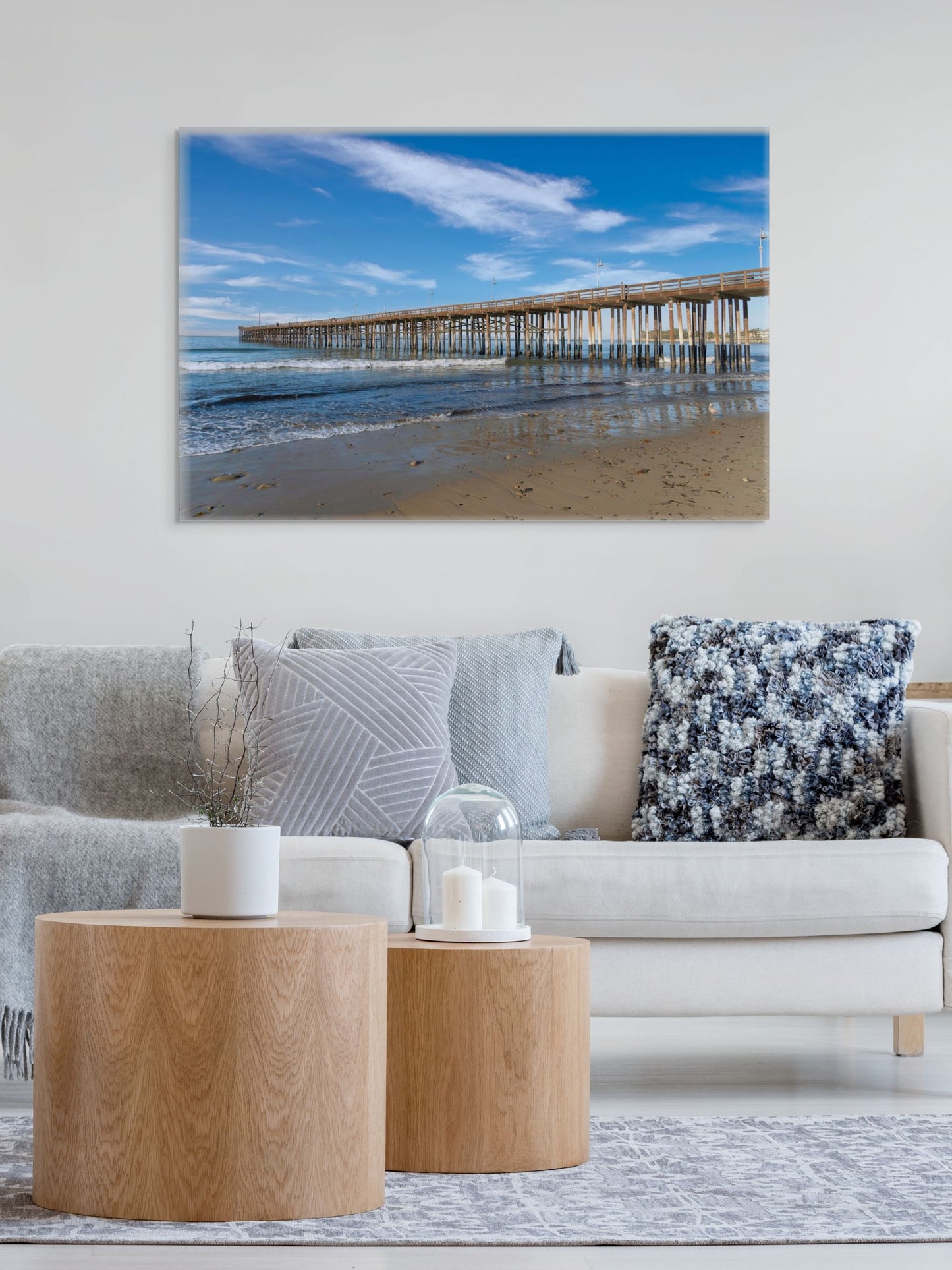 Living room with a couch, coffee table, and a large canvas print of Ventura Pier in California on the wall.