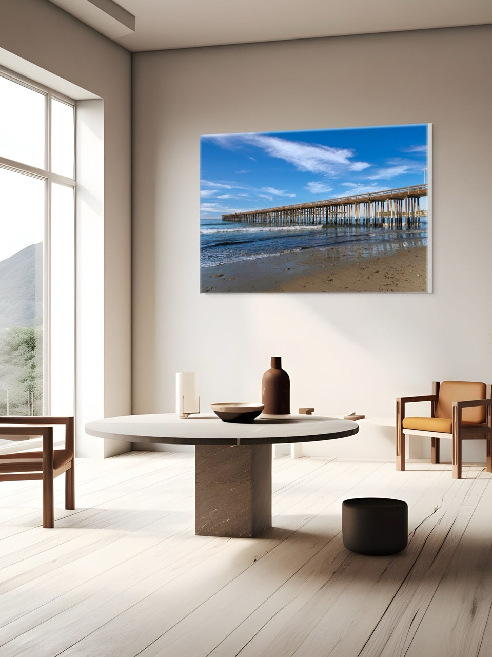 Modern living room with a large canvas print of Ventura Pier in California, wooden furniture, and a vase on a table.