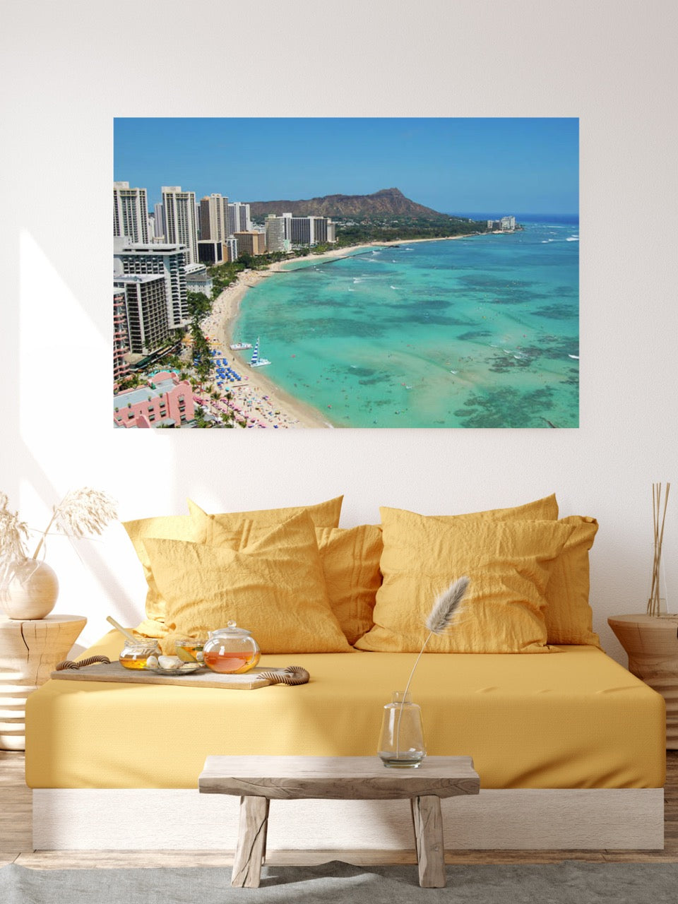 Living room with a yellow couch and a large canvas print of an overhead view of the beach and hotels on Waikiki Beach in Hawaii with Diamond Head in the background.