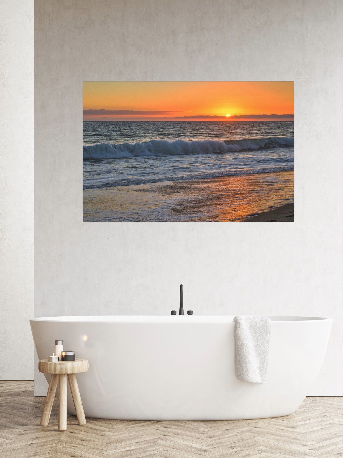 Canvas print of a Zuma Beach sunset in Malibu California with golden sky and reflective sand on a wall above a bathtub in a bathroom.